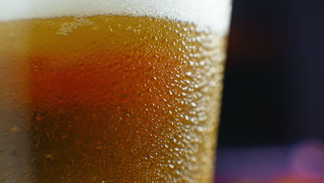 Macro-shot-of-a-beer-glass-with-cold-beer-bubbles-rise-in-the-glass.-Slow-motion-beer-bubbles